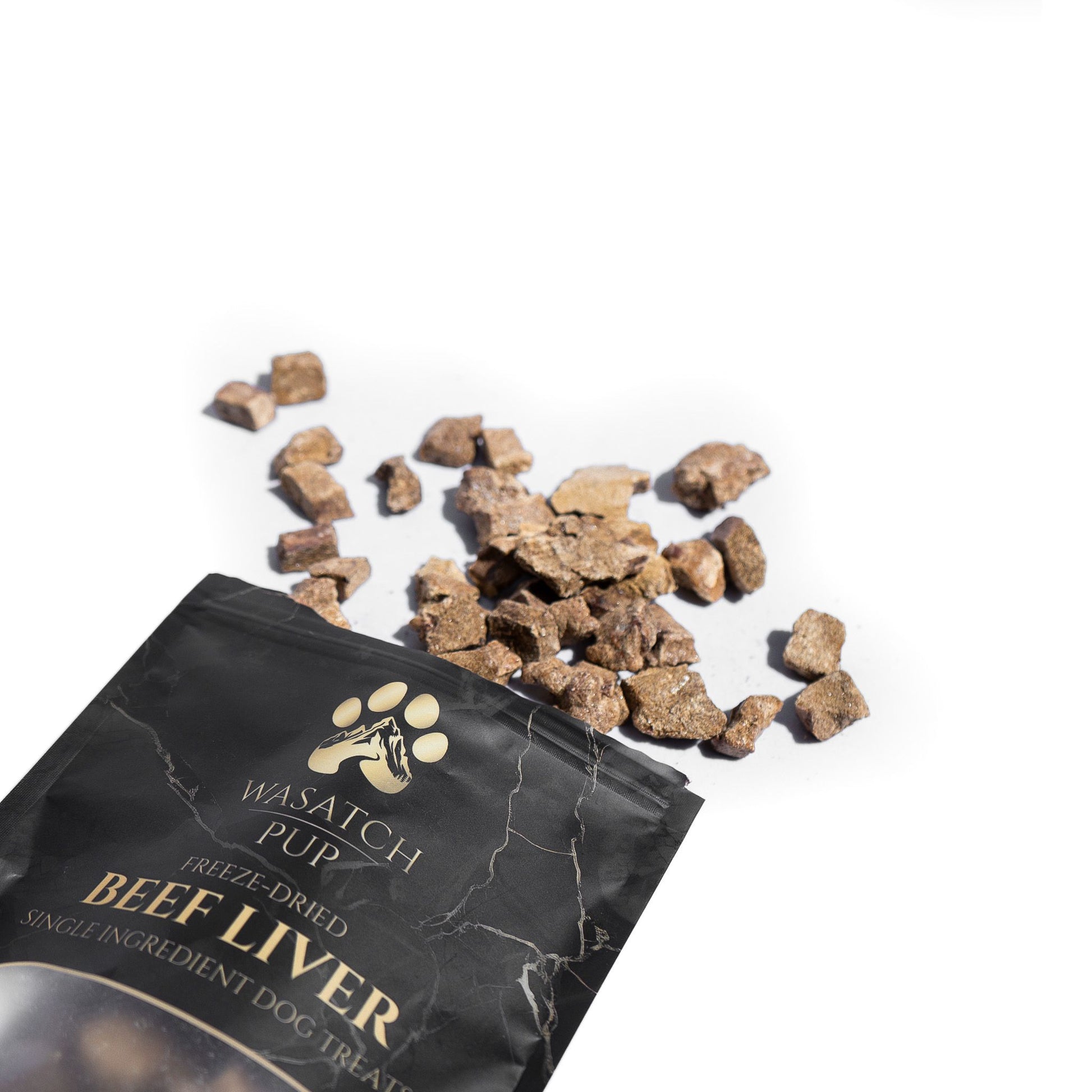 Wasatch Pup natural single-ingredient freeze-dried beef liver dog treats spilling out of the package.